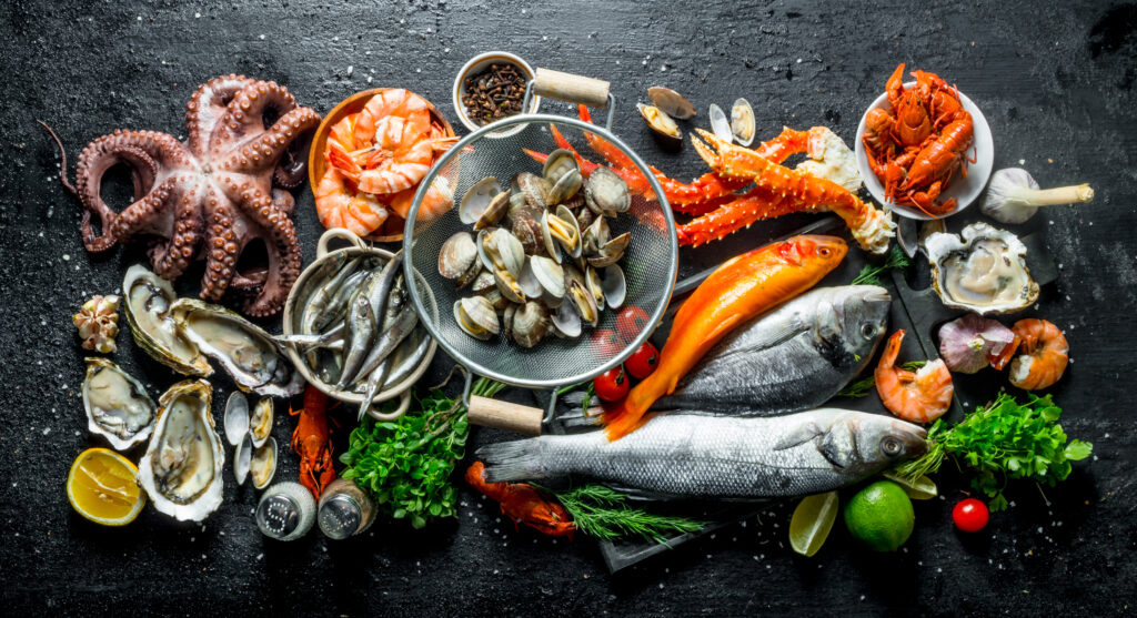 Variety of fresh seafood with herbs and lime.